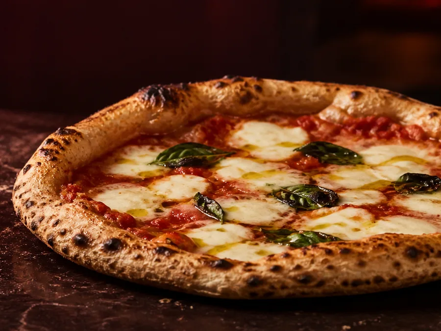 Pizza artisanale entière garnie de mozzarella, tomate et basilic